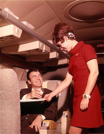 servicing a plane - 1960s 1970s AIRPLANE PLANE STEWARDESS SERVING BUSINESS MAN DRINK WINE WOMAN COMMERCIAL AIR TRAVEL Stock Photo - Rights-Managed, Code: 846-09012817