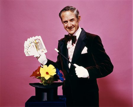 simsearch:400-04279469,k - 1970s MAGICIAN PERFORMING MAGIC CARD TRICK WEARING TUXEDO AND WHITE GLOVES Stock Photo - Rights-Managed, Code: 846-09012868
