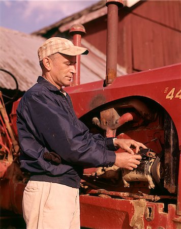 1960s MAN FARMER REPAIRING TRACTOR FARM EQUIPMENT MACHINERY Foto de stock - Con derechos protegidos, Código: 846-09012886