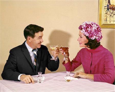 simsearch:846-05647657,k - 1960s COUPLE TOASTING EACH OTHER WITH WINE IN RESTAURANT WOMAN WEARING FLOWERED HAT Photographie de stock - Rights-Managed, Code: 846-09012897