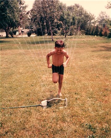 suburban - 1960s 1970s BOY RUNNING THROUGH LAWN SPRINKLER WATER COOL SUMMER FUN BOYS WET Stock Photo - Rights-Managed, Code: 846-09012939