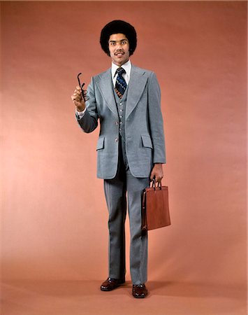 simsearch:846-05648290,k - 1970s SMILING AFRICAN AMERICAN MAN THREE PIECE SUIT BRIEFCASE LOOKING AT CAMERA POINTING GESTURING WITH EYEGLASSES Stock Photo - Rights-Managed, Code: 846-09012992