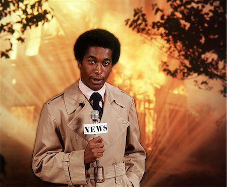 simsearch:846-05648052,k - 1970s AFRICAN AMERICAN MAN TV REPORTER AT SCENE OF FIRE SPEAKING TO MICROPHONE LOOKING AT CAMERA Foto de stock - Con derechos protegidos, Código: 846-09013034