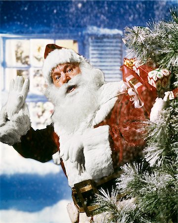 simsearch:846-05647602,k - 1950s 1960s 1970s SANTA CLAUS WITH PACK OF PRESENTS TOYS WAVING IN SNOW IN FRONT OF HOUSE OUTDOOR CHRISTMAS Stock Photo - Rights-Managed, Code: 846-09013030