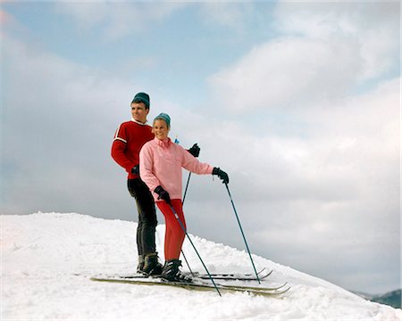 simsearch:846-02797740,k - 1960s COUPLE POSED TOP SNOWY HILL WOMAN PINK SWEATER RED SKI PANTS MAN RED SWEATER SKIS SKIING SPORTS VERMONT USA Stock Photo - Rights-Managed, Code: 846-09013047