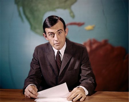 simsearch:846-05648052,k - 1960s NEWSMAN LOOKING AT CAMERA READING NEWS FROM PAPERS SPEAKING INTO MICROPHONE LOOKING AT CAMERA WORLD MAP BACKGROUND Foto de stock - Con derechos protegidos, Código: 846-09013041