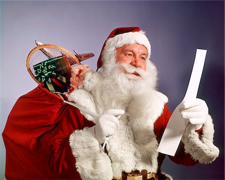 simsearch:846-05647602,k - 1960s SANTA CLAUS READING THE LIST OF NAUGHTY & NICE SMILING CARRY BAG OF TOYS Stock Photo - Rights-Managed, Code: 846-09013058