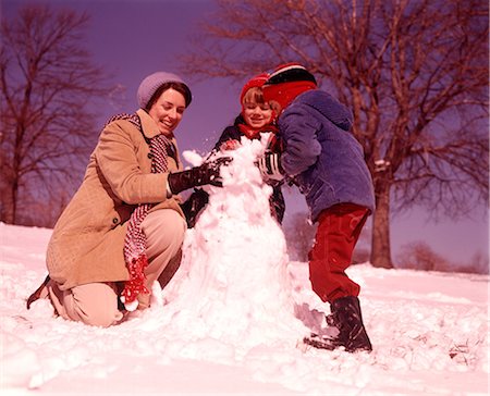 simsearch:846-03163999,k - 1970s SMILING WOMAN MOTHER TWO BOYS SONS BUILDING SNOWMAN TOGETHER Foto de stock - Con derechos protegidos, Código: 846-09013050