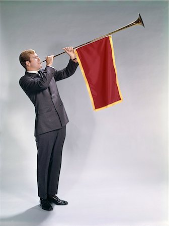 1960s MAN BLOWING PAGEANT TYPE TRUMPET WITH PENNANT FLAG ANNOUNCEMENT EVENT OCCASION Stock Photo - Rights-Managed, Code: 846-09085362