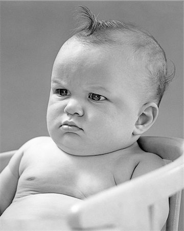 schmollen (beleidigt sein) - 1940s PORTRAIT BABY FROWNING SCOWLING SITTING IN CHAIR Stockbilder - Lizenzpflichtiges, Bildnummer: 846-09161401