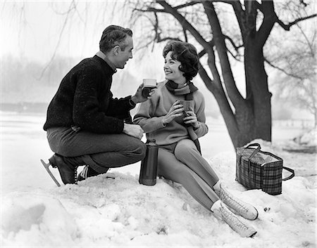 simsearch:846-05646926,k - 1960s SMILING COUPLE IN SNOW WEARING ICE SKATES DRINKING HOT BEVERAGE FROM THERMOS Stock Photo - Rights-Managed, Code: 846-09161413