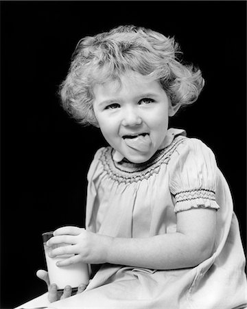 food girl tongue - 1920s 1930s SMILING LITTLE GIRL CURLY SHORT HAIR HOLDING GLASS OF MILK LOOKING AT CAMERA LICKING HER LIPS WITH TONGUE DELICIOUS Stock Photo - Rights-Managed, Code: 846-09161430