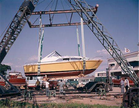 simsearch:846-05645898,k - 1960s BOAT SPEED BOAT BEING LIFTED ON CRANES MEN WORKING DRY DOCK REPAIR STORAGE Stock Photo - Rights-Managed, Code: 846-09161459