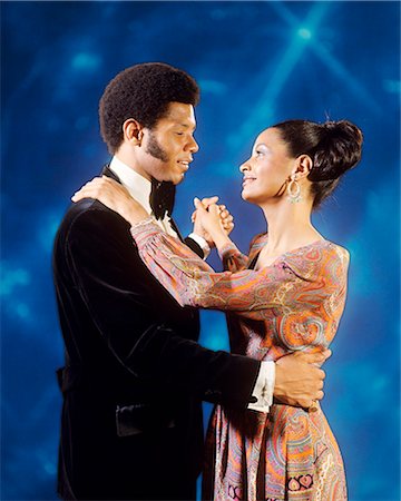 simsearch:846-05646926,k - 1970s AFRICAN AMERICAN COUPLE IN EVENING DRESS SLOW DANCING TOGETHER Stock Photo - Rights-Managed, Code: 846-09161469