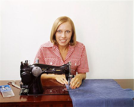 simsearch:846-06111871,k - 1970s WOMAN OPERATING SEWING MACHINE HOUSEHOLD APPLIANCE SEW SKILL CRAFT HOUSEWIFE WEARING CHECKED BLOUSE LOOKING AT CAMERA Stock Photo - Rights-Managed, Code: 846-09161528