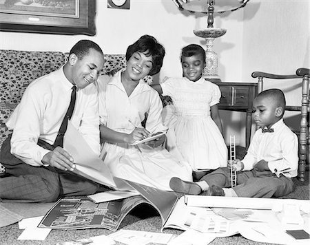 1960s AFRICAN AMERICAN FAMILY LOOKING AT BLUEPRINTS PLANNING FOR A NEW HOME BOY GIRL MOTHER FATHER Photographie de stock - Rights-Managed, Code: 846-09161563