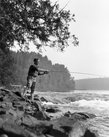 simsearch:846-05646687,k - 1920s MAN SPORTSMAN CASTING FLY FISHING IN WILDERNESS STREAM BRITISH COLUMBIA CANADA Stock Photo - Rights-Managed, Code: 846-09181524