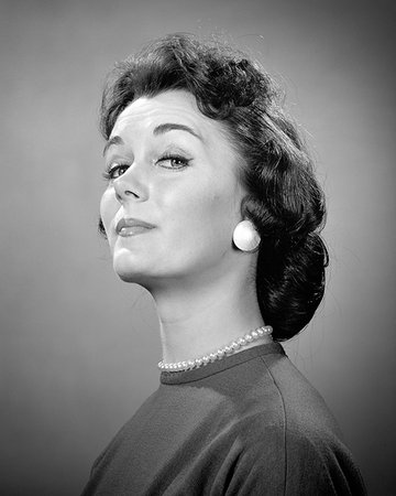 funny fashions - 1950s 1960s BRUNETTE WOMAN EXHIBITING TITLED SUPERIOR SNOBBISH GLOATING CONCEITED SATISFIED FACIAL EXPRESSION LOOKING AT CAMERA Stock Photo - Rights-Managed, Code: 846-09181648