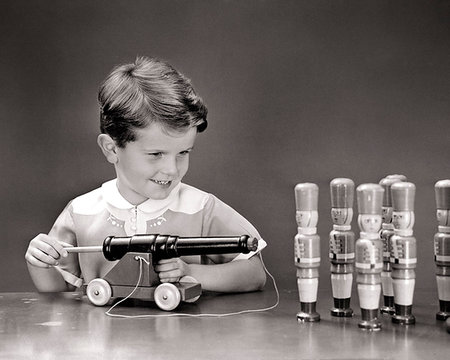 simsearch:846-05647657,k - 1940s SMILING BOY ABOUT TO SHOOT CORK POP GUN TOY CANNON INTO ROW OF TOY WOODEN SOLDIERS Photographie de stock - Rights-Managed, Code: 846-09181676