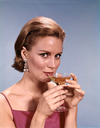 simsearch:846-05646926,k - 1960s GLAMOROUS WOMAN WEARING EARRINGS SIPPING COCKTAIL WINE CHAMPAGNE LOOKING AT CAMERA Stock Photo - Rights-Managed, Code: 846-09181776