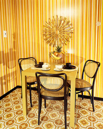 simsearch:846-03164688,k - 1970s DINING NOOK ORANGE AND YELLOW STRIPED WALLPAPER ORANGE TABLE BROWN WICKER CHAIRS SUNBURST MEDALLION ON WALL Photographie de stock - Rights-Managed, Code: 846-09181804