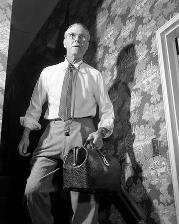 1940s 1950s DOCTOR WITH BAG AND STETHOSCOPE WALKING DOWN STAIRS IN HOME AFTER MAKING AN EMERGENCY HOUSE CALL Photographie de stock - Rights-Managed, Code: 846-09181919