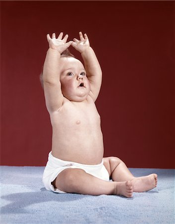 1960s BABY WEARING CLOTH DIAPER SITTING ARMS RAISED OVER HEAD Stock Photo - Rights-Managed, Code: 846-02794026