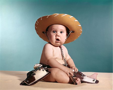 1960s BABY WEARING COWBOY COSTUME WITH FUNNY FACIAL EXPRESSION Stock Photo - Rights-Managed, Code: 846-02794068