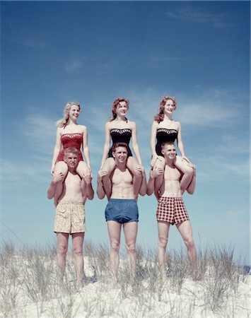 1950s THREE TEENAGE COUPLES STANDING ON SAND DUNE GIRLS SITTING ON GUYS SHOULDERS Stock Photo - Rights-Managed, Code: 846-02794079