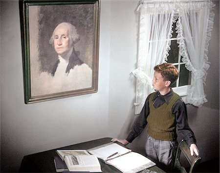 1940s 1950s BOY STANDING BY DESK SPREAD WITH HOMEWORK LOOKING UP AT PAINTING OF GEORGE WASHINGTON Stock Photo - Rights-Managed, Code: 846-02794433