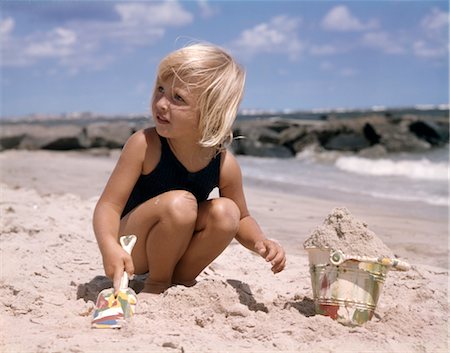 retro shovel - 1950s 1960s BLOND LITTLE GIRL PLAYING IN THE SAND WITH PAIL AND SHOVEL AT OCEAN SEASHORE BEACH Stock Photo - Rights-Managed, Code: 846-02794444