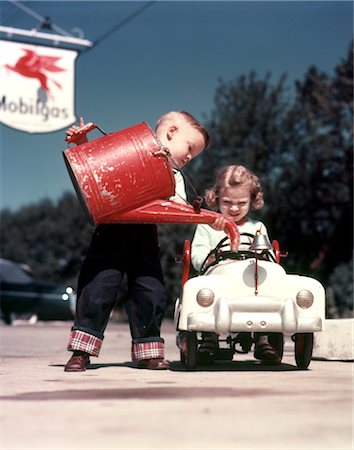 petrol station - 1950s LITTLE BOY PRETENDING TO SERVICE PEDDLE TOY CAR FIRE ENGINE FOR LITTLE GIRL Stock Photo - Rights-Managed, Code: 846-02794476