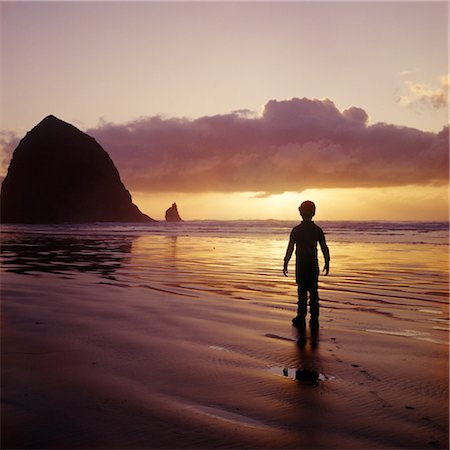 simsearch:846-02794130,k - SILHOUETTED BOY WALKING ON BEACH AT SUNSET HAYSTACK ROCK NEAR CANNON BEACH OREGON Stock Photo - Rights-Managed, Code: 846-02794543