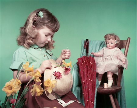 1950s GIRL CHILD SEWING FLOWERS ON STRAW HAT DAFFODILS BABY DOLL TOY HIGH CHAIR UMBRELLA SPRING EASTER BONNET Stock Photo - Rights-Managed, Code: 846-02794553