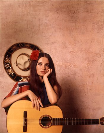 1970 1970s MOODY SERIOUS LATIN SPANISH HISPANIC WOMAN LEANING ON GUITAR MEXICAN SOMBRERO ON WALL Stock Photo - Rights-Managed, Code: 846-02794787