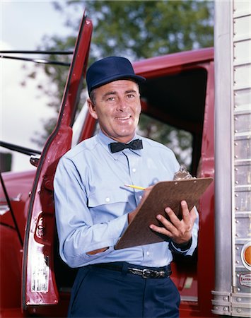 1950s 1960s MAN DRIVER DELIVERY SERVICE REPAIRMAN IN UNIFORM CAP BOW TIE HOLDING CLIPBOARD STANDING IN OPEN DOOR OF TRUCK CAB Stock Photo - Rights-Managed, Code: 846-02794844