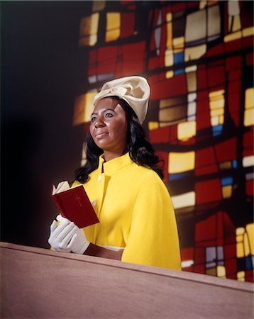 1970s AFRICAN AMERICAN WOMAN SITTING IN CHURCH PEW WEARING WHITE HAT GLOVES YELLOW COAT HOLD RED PRAYER BOOK STAINED GLASS BACKGROUND Stock Photo - Rights-Managed, Code: 846-02794892