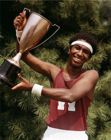 1970s AFRICAN AMERICAN YOUNG MAN ATHLETE HOLDING TRACK & FIELD TROPHY Stock Photo - Rights-Managed, Code: 846-02795068