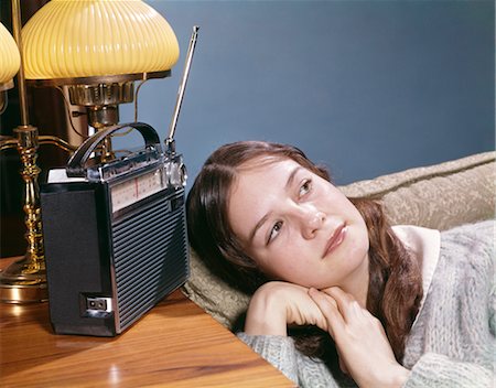 photographs of radio communication - 1960s TEEN GIRL LYING ON COUCH LISTENING TO MUSIC ON PORTABLE TRANSISTOR RADIO Stock Photo - Rights-Managed, Code: 846-02795219