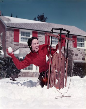 1950s WOMAN HIDING BEHIND SLED THROWING SNOWBALL FRONT STONE HOUSE Stock Photo - Rights-Managed, Code: 846-02795240