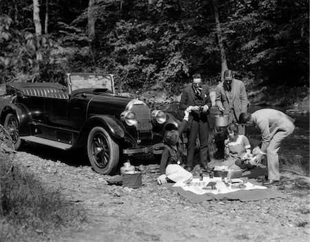 1920s GROUP OF FIVE WITH BLANKET LAID OUT IN FRONT OF CONVERTIBLE ALONG SIDE OF CREEK HAVING PICNIC Stock Photo - Rights-Managed, Code: 846-02795463