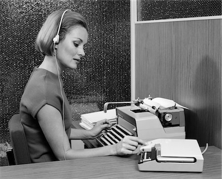 1960s SIDE VIEW OF SECRETARY AT DESK BEHIND TYPEWRITER WEARING HEADSET & TURNING KNOB ON DICTAPHONE Stock Photo - Rights-Managed, Code: 846-02795849