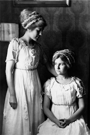 1890s 1900 TURN OF THE CENTURY PAIR OF YOUNG WOMEN SISTERS WITH GARLANDS IN HAIR MATCHING TRIM ON DRESSES Stock Photo - Rights-Managed, Code: 846-02795980