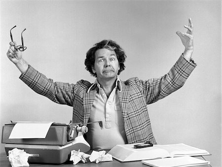 1970s MAN AT DESK TYPEWRITER CRUMPLED PAPERS ARMS UP IN AIR EXASPERATED EXPRESSION INDOOR Stock Photo - Rights-Managed, Code: 846-02796005
