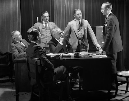 1930s FIVE OLDER BUSINESSMEN MEETING AROUND A DESK LISTENING TO A SIXTH YOUNGER MAN SPEAK Stock Photo - Rights-Managed, Code: 846-02796056