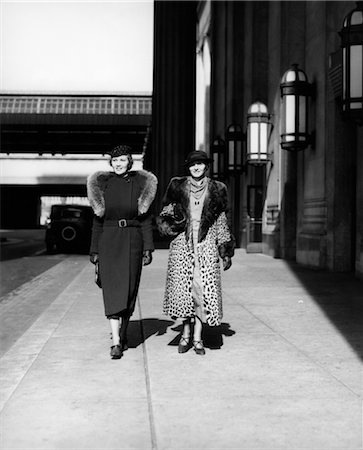 panther - 1930s TWO WOMEN WALKING BY 30th STREET TRAIN STATION ONE WEARING COAT WITH FUR STOLE THE OTHER WEARING LEOPARD FUR COAT OUTDOOR Stock Photo - Rights-Managed, Code: 846-02796193