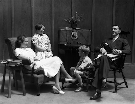 simsearch:846-02795935,k - 1930s FAMILY MAN FATHER WOMAN MOTHER GIRL DAUGHTER BOY SON IN LIVING ROOM GATHERED AROUND LISTENING TO RADIO Stock Photo - Rights-Managed, Code: 846-02796545