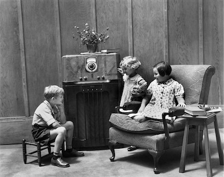 photographs of radio communication - 1930s TWO LITTLE GIRLS AND A BOY SITTING IN LIVING ROOM LISTENING TO RADIO Stock Photo - Rights-Managed, Code: 846-02796547