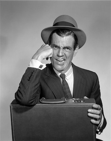 disgusted face vintage - 1960s DISGUSTED MAN WITH SCOWL ON FACE WEARING HAT SHIRT TIE SUIT ONE ELBOW RESTING ON BRIEFCASE ANGRY UPSET Stock Photo - Rights-Managed, Code: 846-02796849