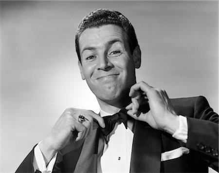 1950s SMILING MAN IN TUXEDO TYING BLACK BOWTIE WITH BOTH HANDS PERKY UPBEAT DAPPER CONFIDENT CRISP Stock Photo - Rights-Managed, Code: 846-02796894